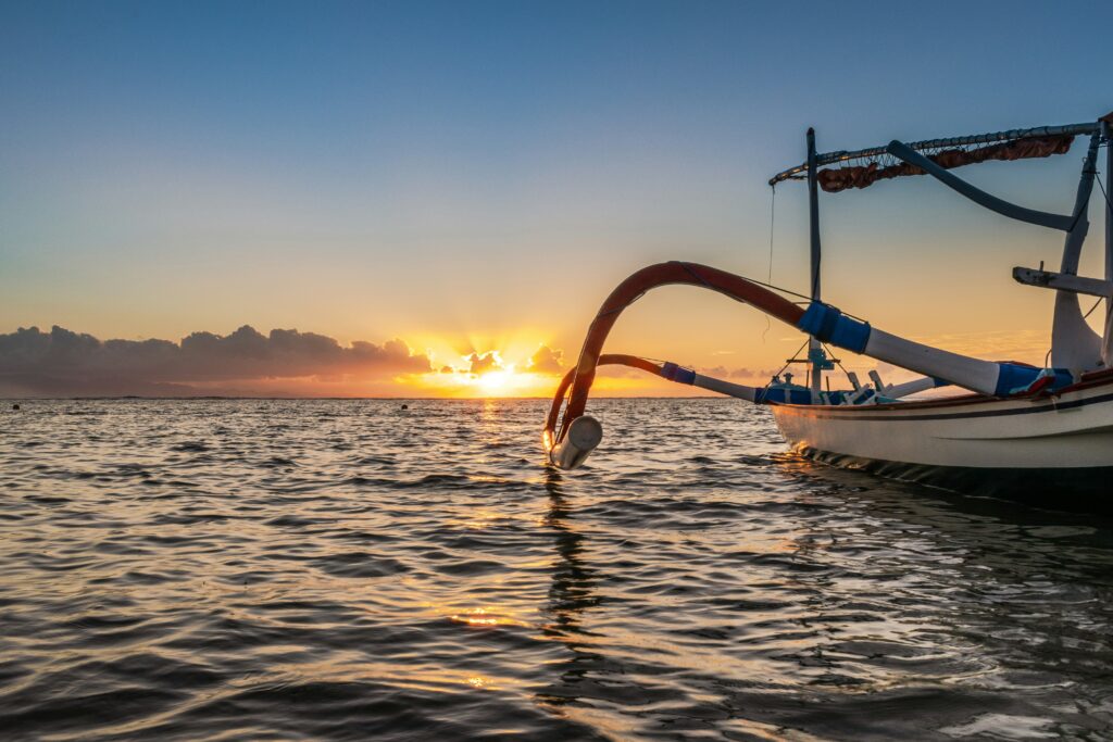 bootje op zee tijdens zonsondergang